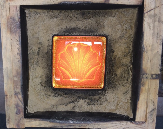 Molten glass cast of a scallop shell